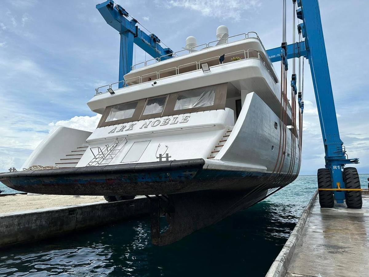 Motor yacht in the slings of a heavy travel lift during haul-out